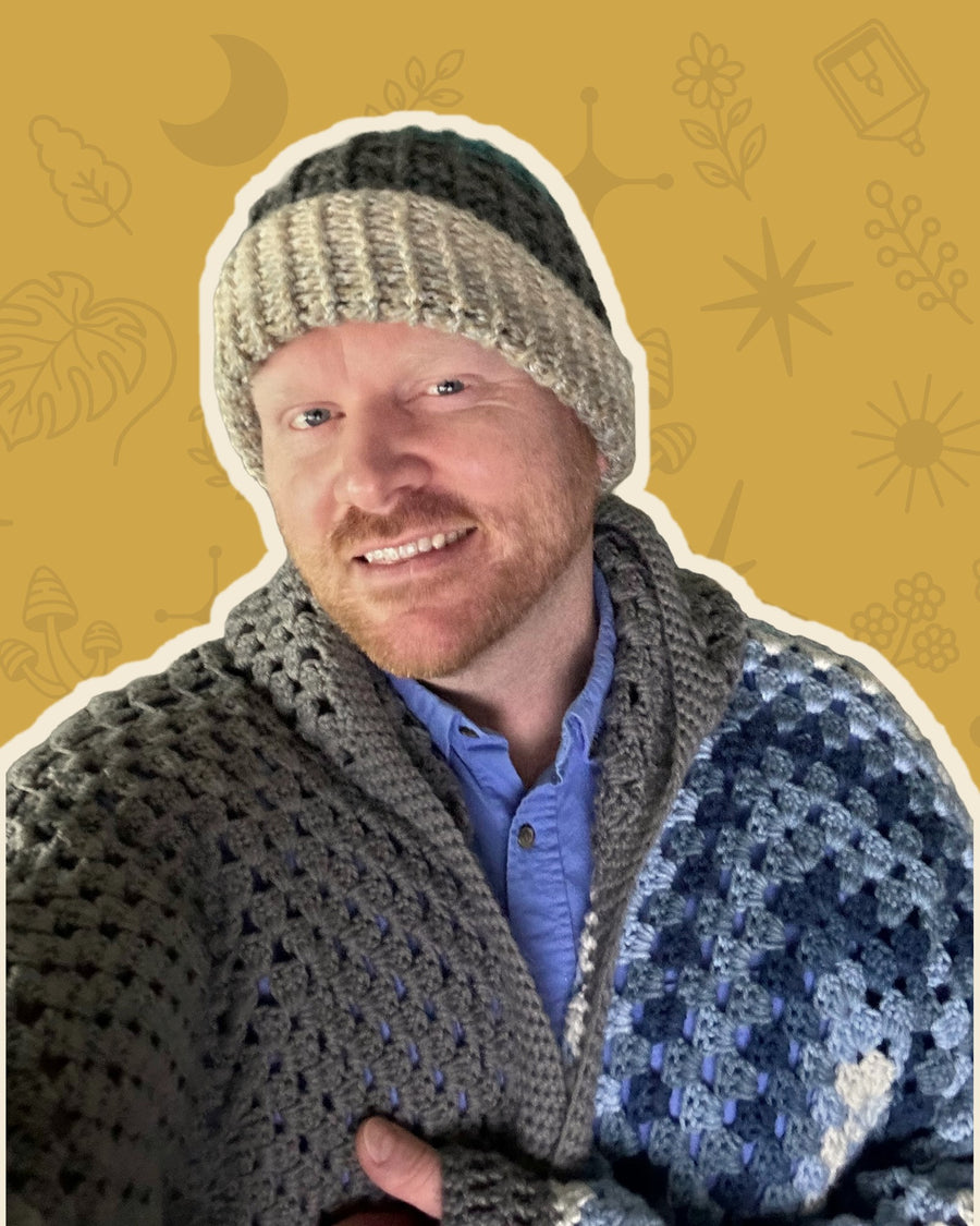Walker, the artist behind Hooked & Trying, smiling on a mustard background