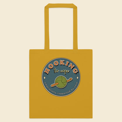 Mustard cotton tote bag with Hooking to Cope crochet badge artwork