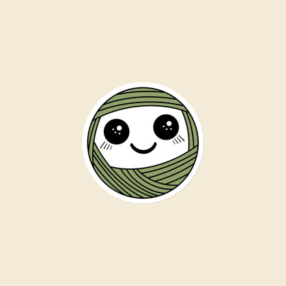 Pip, a sparkly-eyed, blushing sage green Yarn Creature magnet, 3 × 3 in, on a cream background