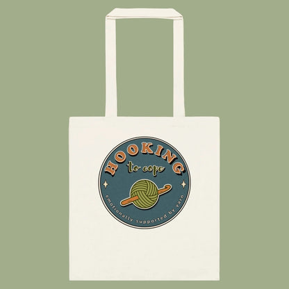 Natural cotton tote bag with Hooking to Cope crochet badge artwork