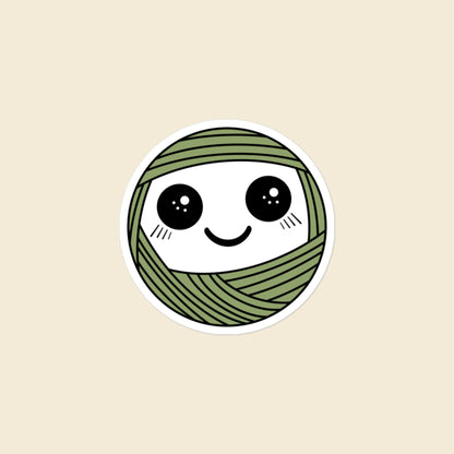 Pip, a sparkly-eyed, blushing sage green Yarn Creature sticker, 3 × 3 in, on a cream background