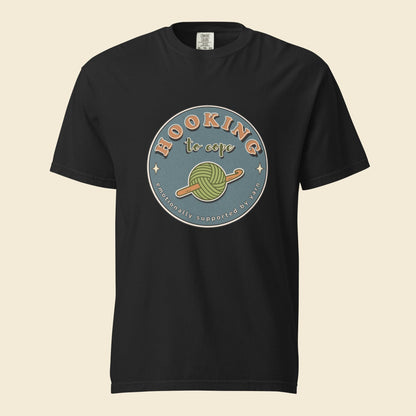 Black heavyweight T-shirt with Hooking to Cope crochet badge artwork