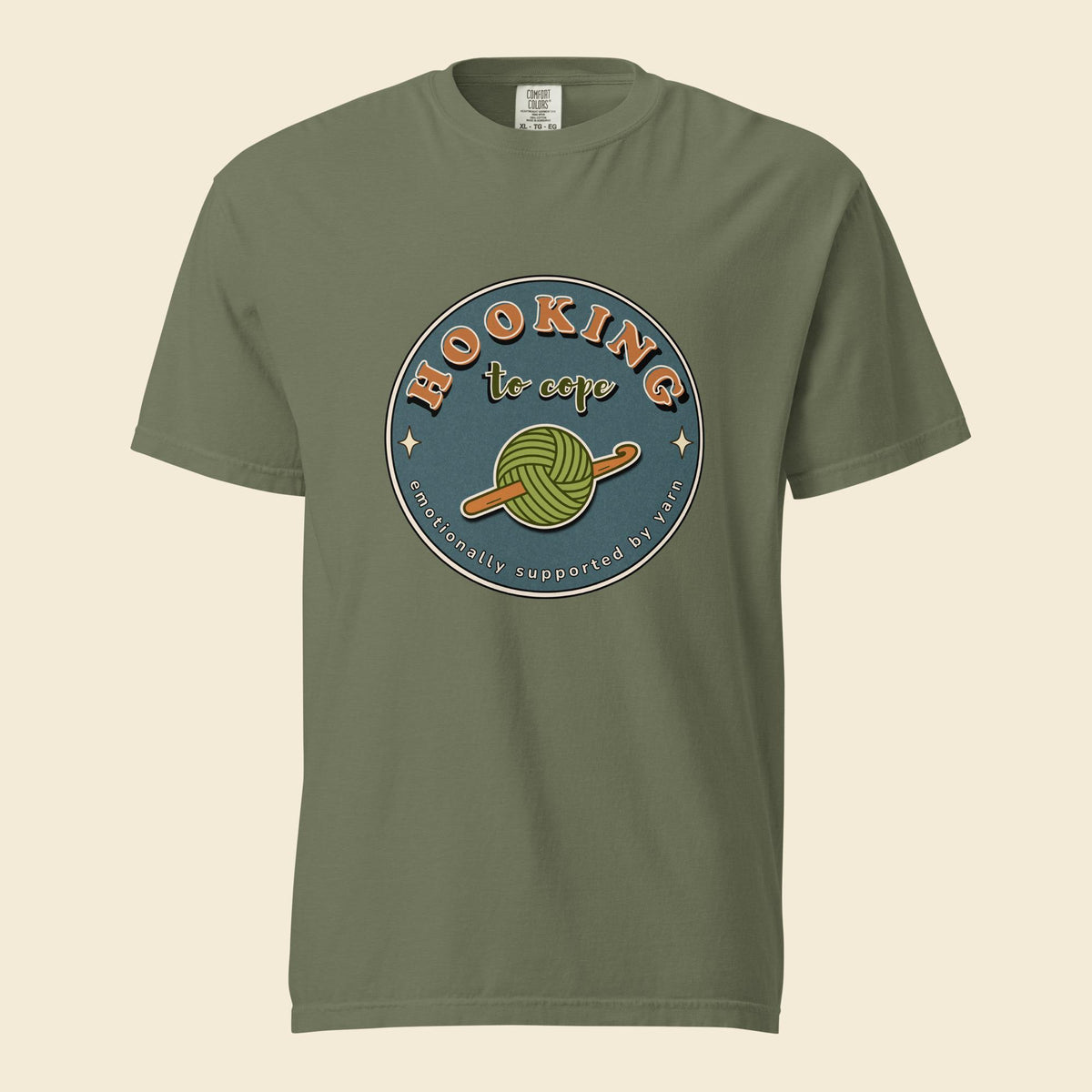 Moss heavyweight T-shirt with Hooking to Cope crochet badge artwork